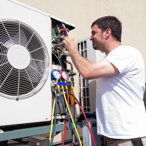 HVAC technician working on a mini-split condensing unit