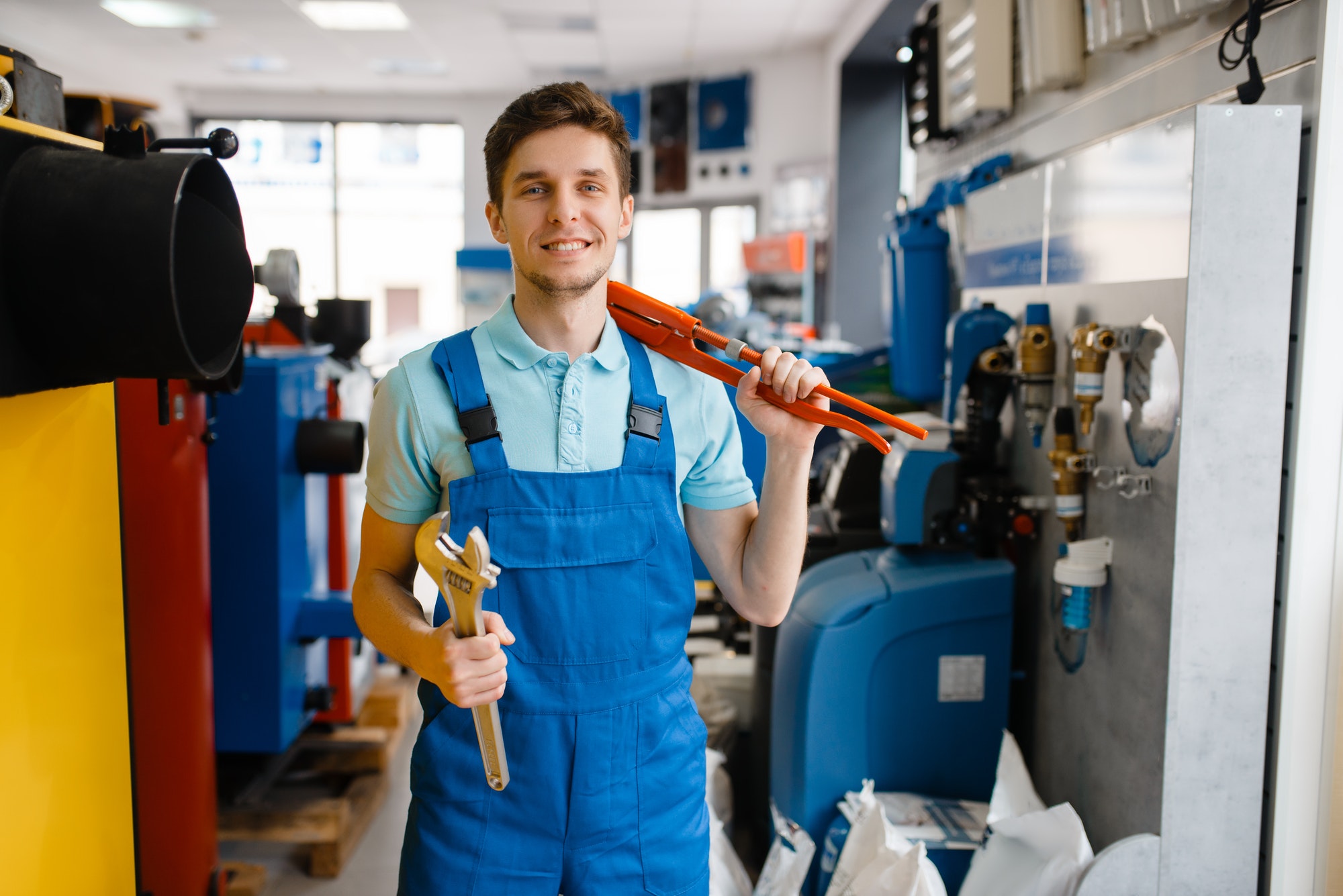 plumber-shows-pipe-wrenches-in-plumbering-store